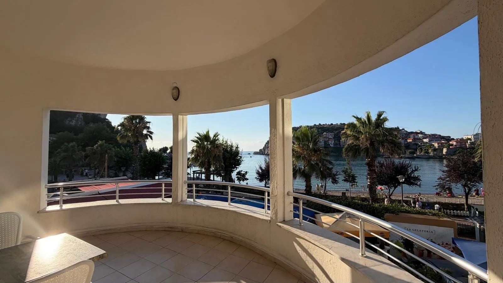 Aile odasının kavisli balkonundan kumsal, palmiyeler ve Amasra koyu